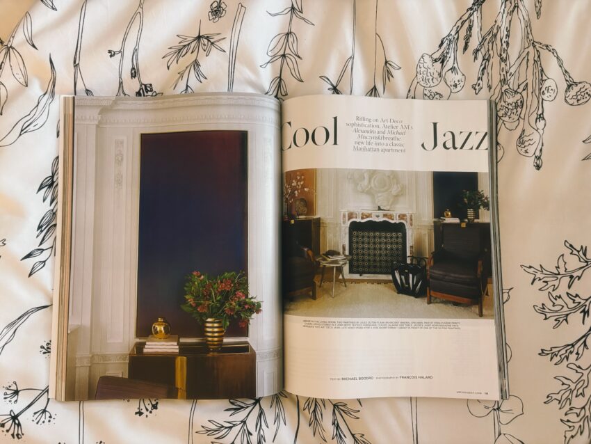“A serene magazine spread on a black-and-white leaf pattern comforter, bathed in soft sunlight — capturing the calm luxury of a morning moment, with the pages of a well-curated read waiting to be explored for the This is Kendra blog.