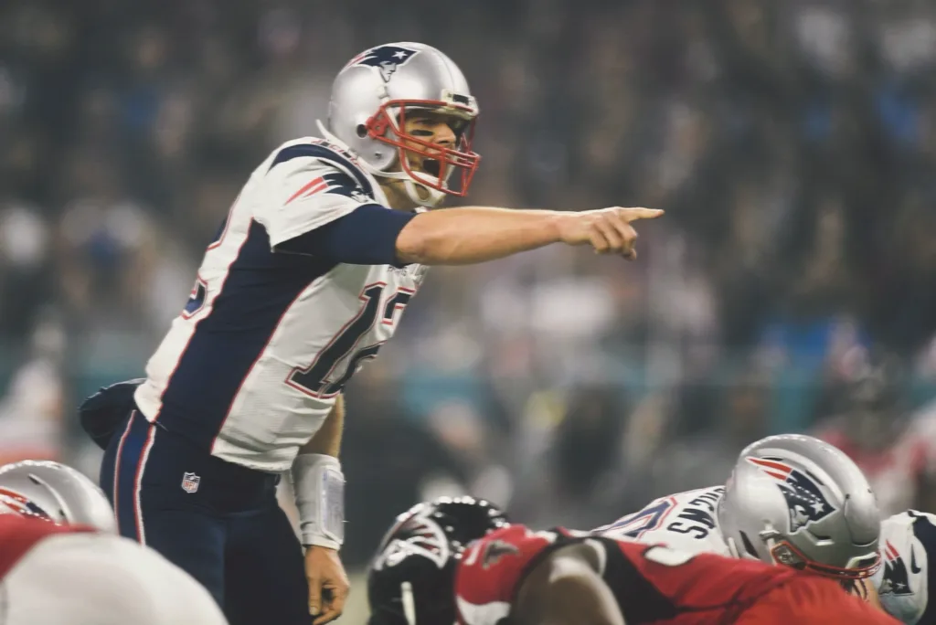 Tom Brady playing quarterback for the New England Patriots during an NFL game.
