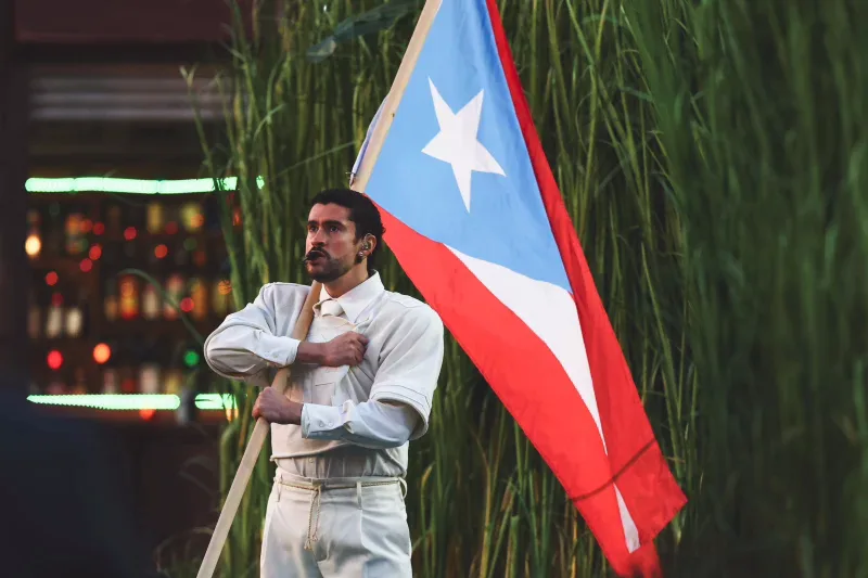 Bad Bunny dressed in white holding the Puerto Rican flag during his Super Bowl LIX halftime performance, photographed by Kevin Sabitus for Getty Images